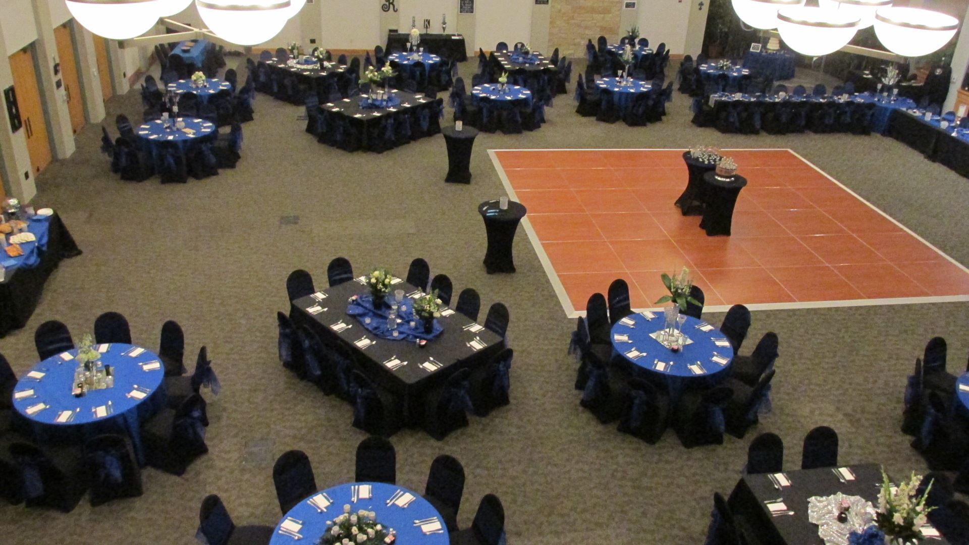 Aerial view of Royal wedding reception of black and blue table settings with dance floor in the midd